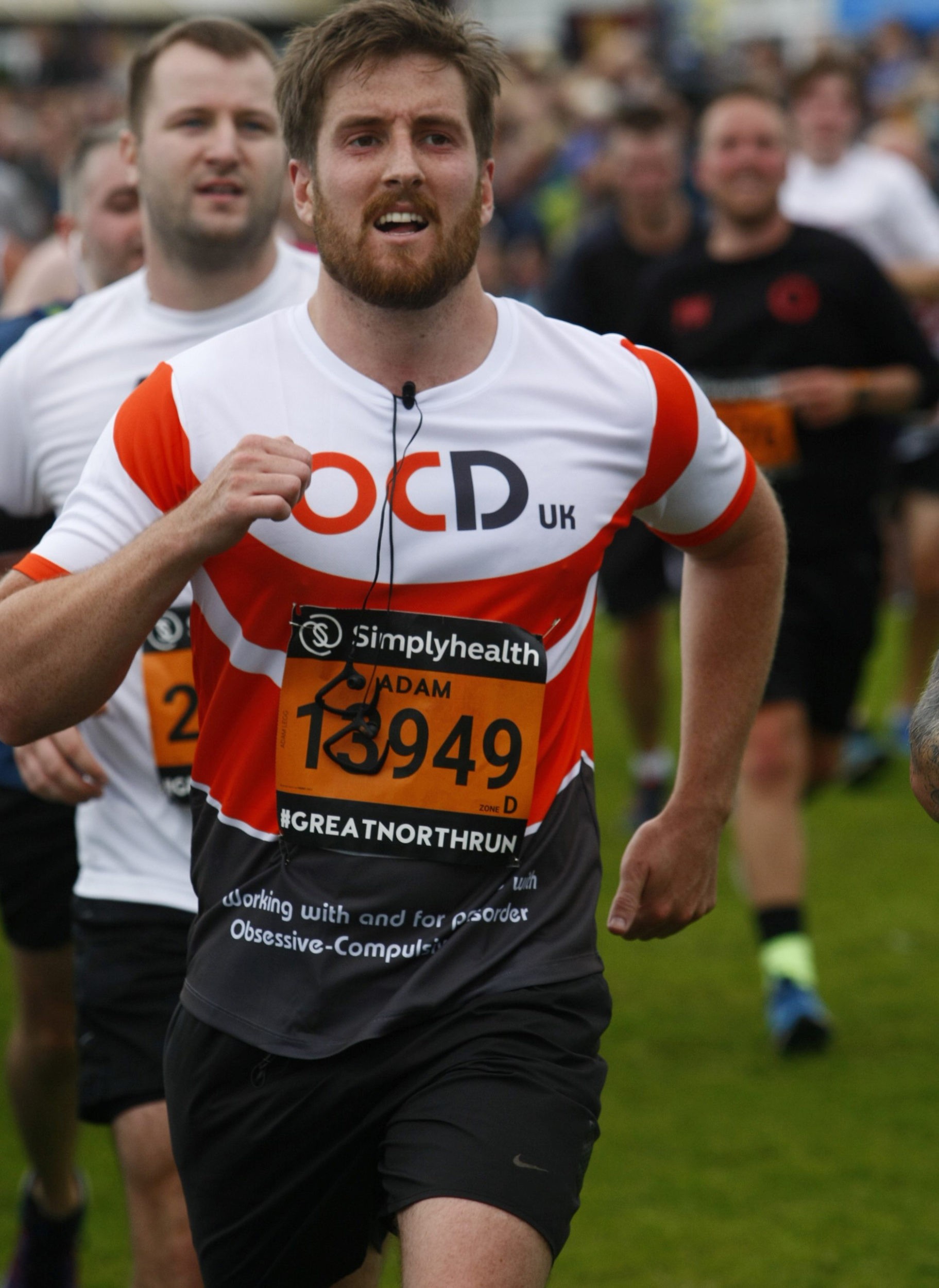 Adam wearing his OCD-UK t-shirt running over some grass during the 2017 Great North Run.