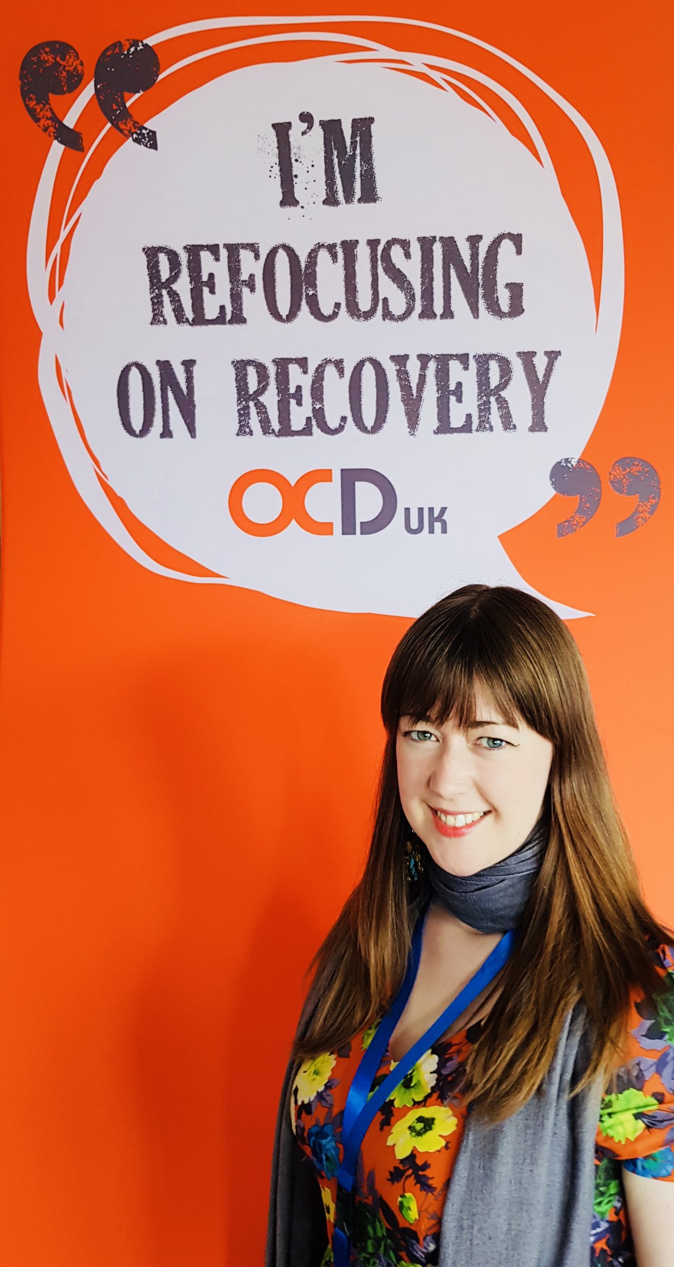Sue standing in front of an orange OCD-UK banner