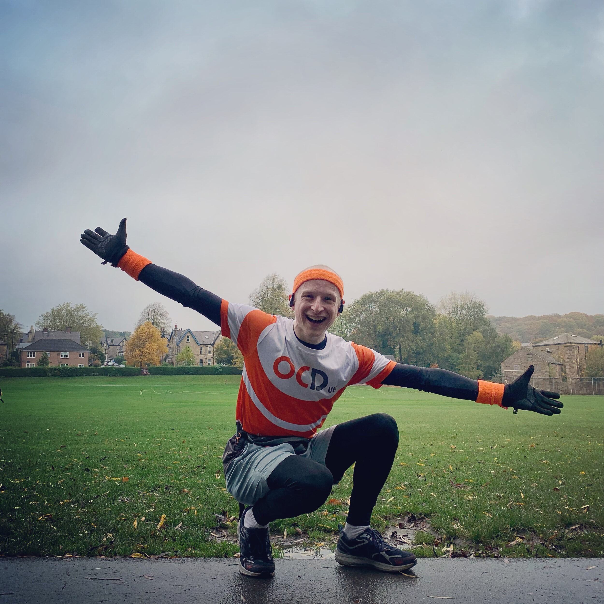 Kirstie crosses the finish line with her OCD-UK t-shirt and beaming smile with her arms in the air.